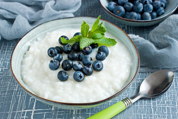 Tasty breakfast: rice pudding with blueberries and  mint leaves