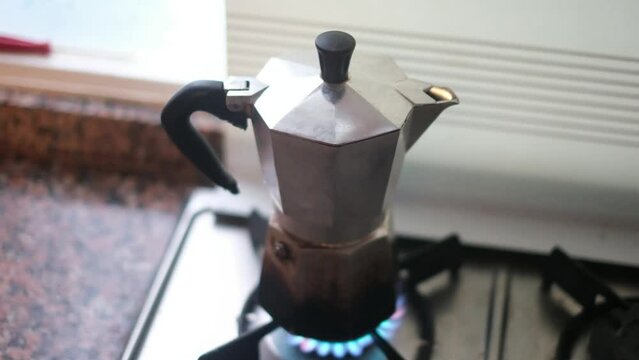 Freshly made coffee image with coffee maker, the moka pot is a stove-top or electric coffee maker that brews coffee by passing boiling water pressurized by steam through ground coffee. 