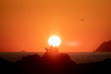 Fototapeta na wymiar Pareja y perro en puesta de sol