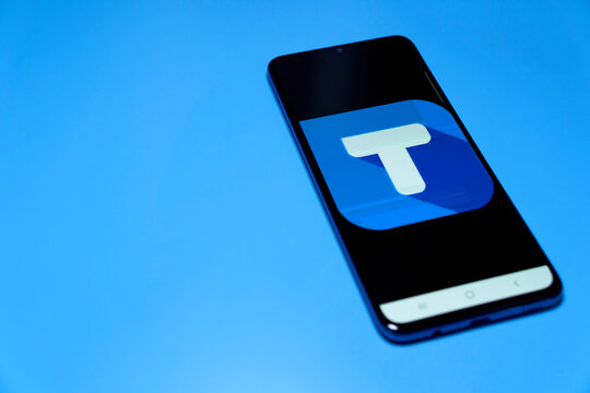 T on smartphone screen. white letter on blue background.