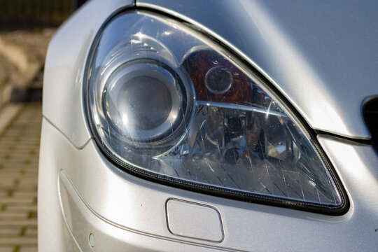 Headlight modern prestigious car close up. Close up photo of modern car, detail of headlight background