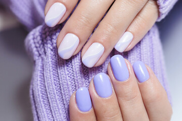 Female hands with a purple colour nails close-up. Nail design. Artistic manicure with a purple nail...