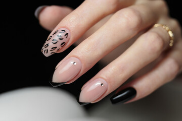 Manicure with gel polish. Female nails with pink and black colours.