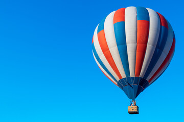 multi-colored balloon with a basket for transporting people