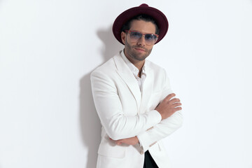 happy elegant man wearing hat and glasses, crossing arms and smiling
