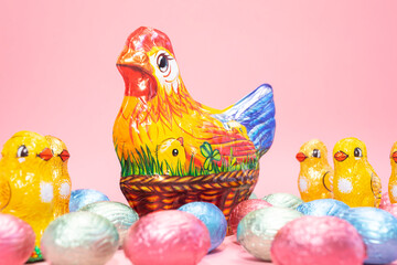 Closeup Chocolate hen, little chickens with colorful bright sweet eggs wrapped in foil on festive...