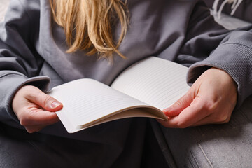 A woman's hand is holding a blank notepad with copy space. Place for text