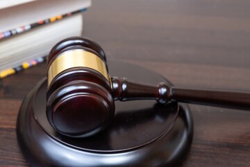 Judge's gavel on wooden table, background of legal books. Concept of legal legislation