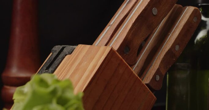 Takes out knife from set to use it, close-up