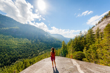 Hiking woman reaching amazing viewpoint on famous Squamish Stawamus Chief Mountain Hike in British Columbia nature landscape. Popular outdoor activity destination in Canada