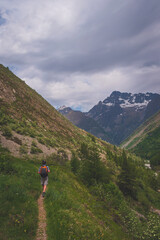 A male hiker walking in the Alps mountains in summer (Valgaudemar valley, Les Oulles du Diable hike)