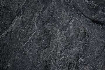 Close-up of a unique and beautiful rock surface, front view. Abstract full frame natural textured dark background in black and white.