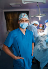 Fototapeta na wymiar Surgeon in mask and uniform in operative room. Healthcare surgical specialist.