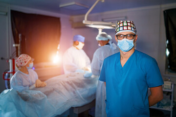 Fototapeta na wymiar Portrait of doctor in uniform and protective mask. Surgery specialist standing in operating room.