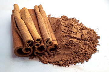Cinnamon sticks and powder close-up view, macro photography, isolated on white background high quality details