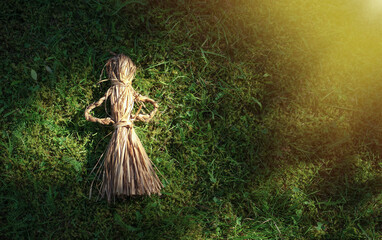 A woven doll made of dry grass lies on the ground. Old ways of making toys in ancient times. Transfer of weaving knowledge from generation to generation.A toy made of reeds.