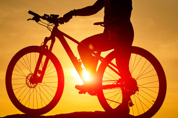 Outdoor sunset bicycle rider. Silhouette of cyclist travelling.