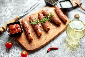 sausages wrapped in bacon, grilled on a stone background