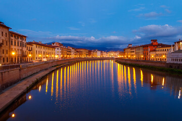 Fototapeta na wymiar Panoramic view of the old town of Pisa and the Arno river at twilight, Italy. Night cityscape
