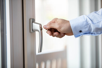 Obraz premium Closeup of a hand locking balcony door daytime