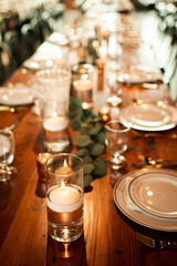 Wedding Day Reception Table Decoration on Wooden Table with Candles and Proper Place Settings