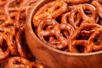 Crispy pretzel crackers with salt crystals in wooden bowl