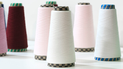 Reels of textile yarn blue thread at industrial weaving manufacturing machine