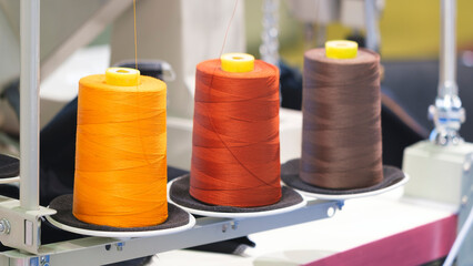 Reels of textile yarn blue thread at industrial weaving manufacturing machine,  textile fabric production industrial concept background