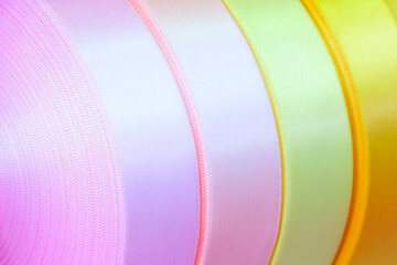 a set of a number of coils of satin ribbons in different colors for the label or decoration close-up as a texture background