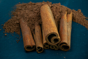 Cinnamon sticks close-up view, macro photography, isolated on black wooden background high quality details