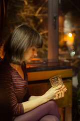 Blurred pretty woman with whiskey glass. Beautiful girl drinking cocktail. Defocused girl in restaurant. Lady in cafe, retro style. Elegant lady in the night. Big city lifestyle.