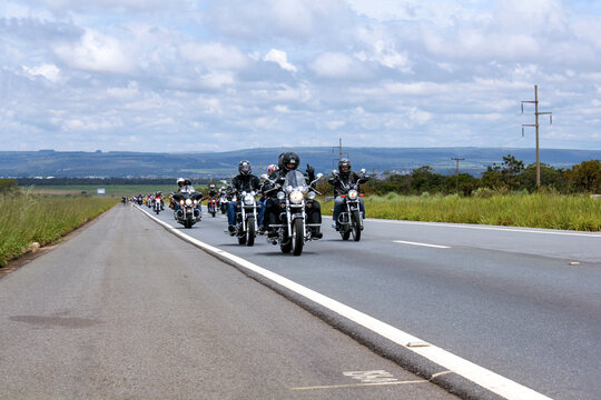 motorcyclists riding in convoy along the road