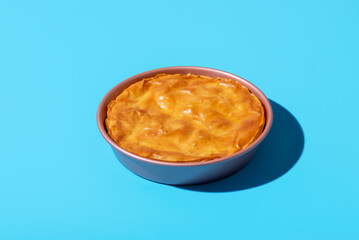 Balkan phyllo spinach cake isolated on a blue background.
