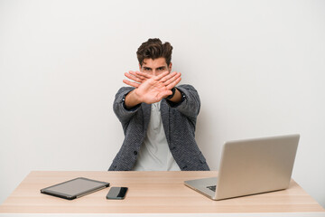 Young entrepreneur man working with a laptop isolated doing a denial gesture