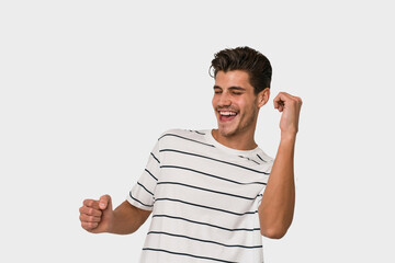 Young handsome caucasian man isolated on white background dancing and having fun.