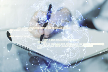 Abstract creative coding concept with world map and man hand writing in notebook on background. Multiexposure
