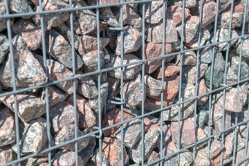 Decoration of the sidewalk path with a metal mesh with natural stone, gravel. Landscaping of the area. Close-up