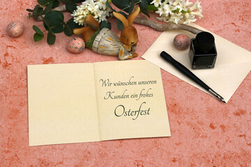 Ostereier, Blumen und ein Brief mit Ostergrüßen: Auf einer Karte steht der Text wir wünschen...