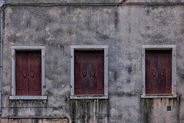 Fototapeta na wymiar three covered windows on the old house