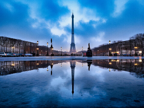 40 mots clés pour décrire une image, séparés par des virgules, en anglais : Paris on a rainy day at dawn, the Eiffel tower reflecting in a puddle
