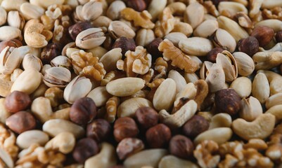 mixed nuts in a bowl on wooden table, top view with copy space.