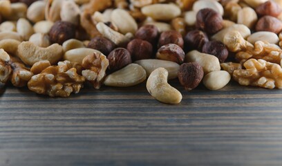 mixed nuts in a bowl on wooden table, top view with copy space.