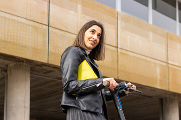 portrait of a smiling businesswoman with an electric scooter