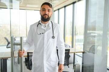 Portrait of pleasant young Arabian doctor in white coat.