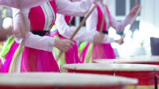 actors in national Korean costumes play drums. 