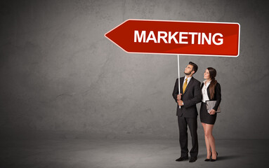 Young business person in casual holding road sign