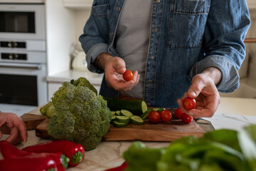 Close-up of a man preparing a salad at home.