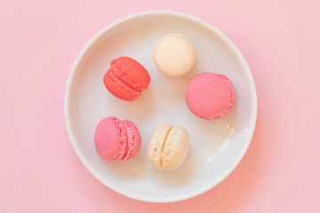 Macaroon selection in feminine colors like pink, red and egg white. Premium dessert selection in a top view image.