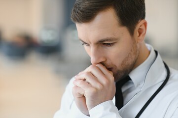 Praying for a successful operation. Cropped shot of a handsome male doctor praying.