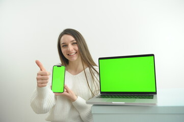 Chromakey. Laptop and phone with green screen on wooden table in home interior. High quality photo